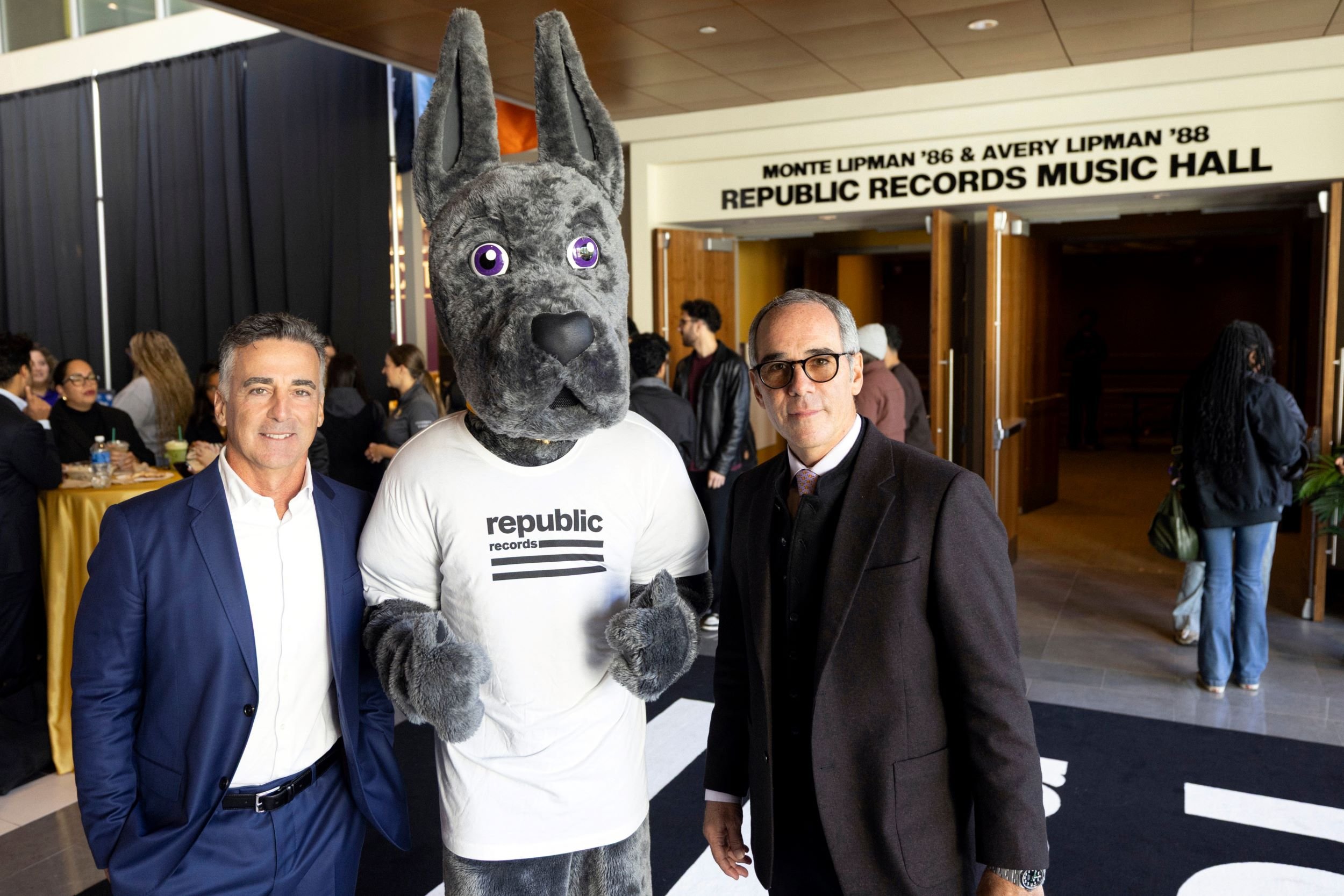 Avery Lipman, left, Damian the Great Dane mascot and Monte Lipman, right, stand in front of the auditorium named in their honor.