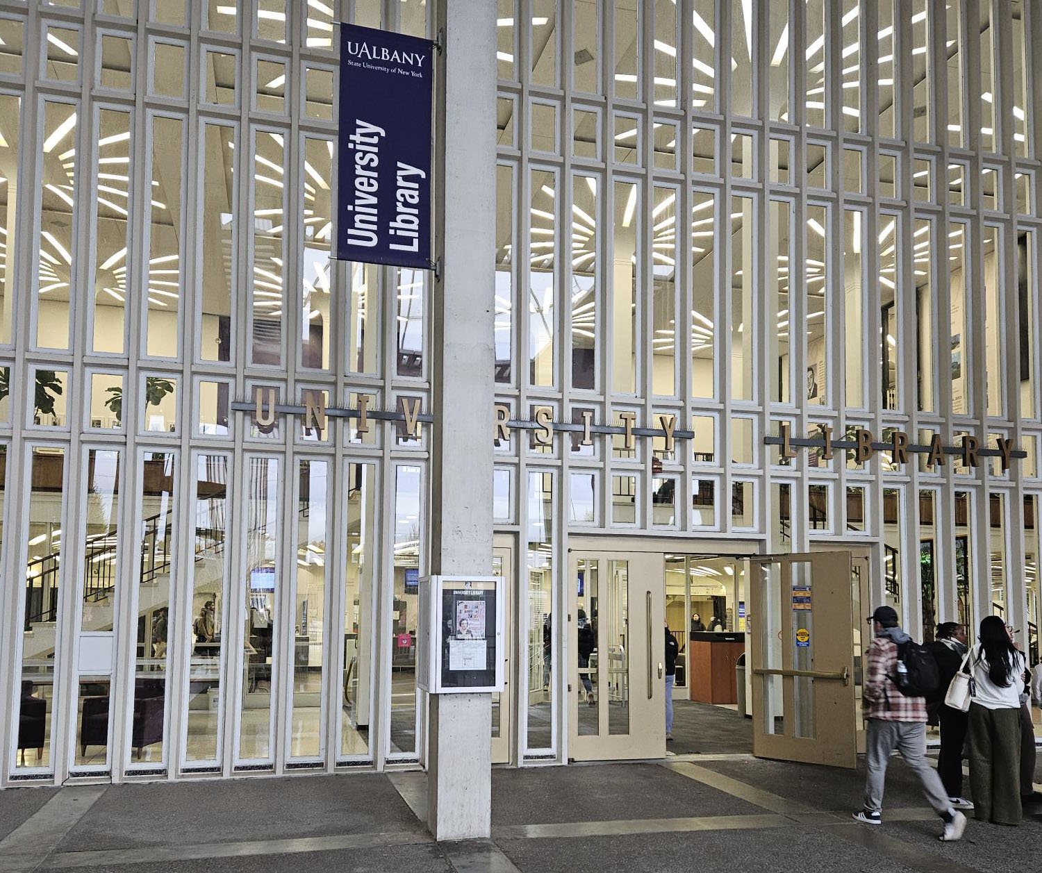 Students walk in and out of the main entrance to the University Library.