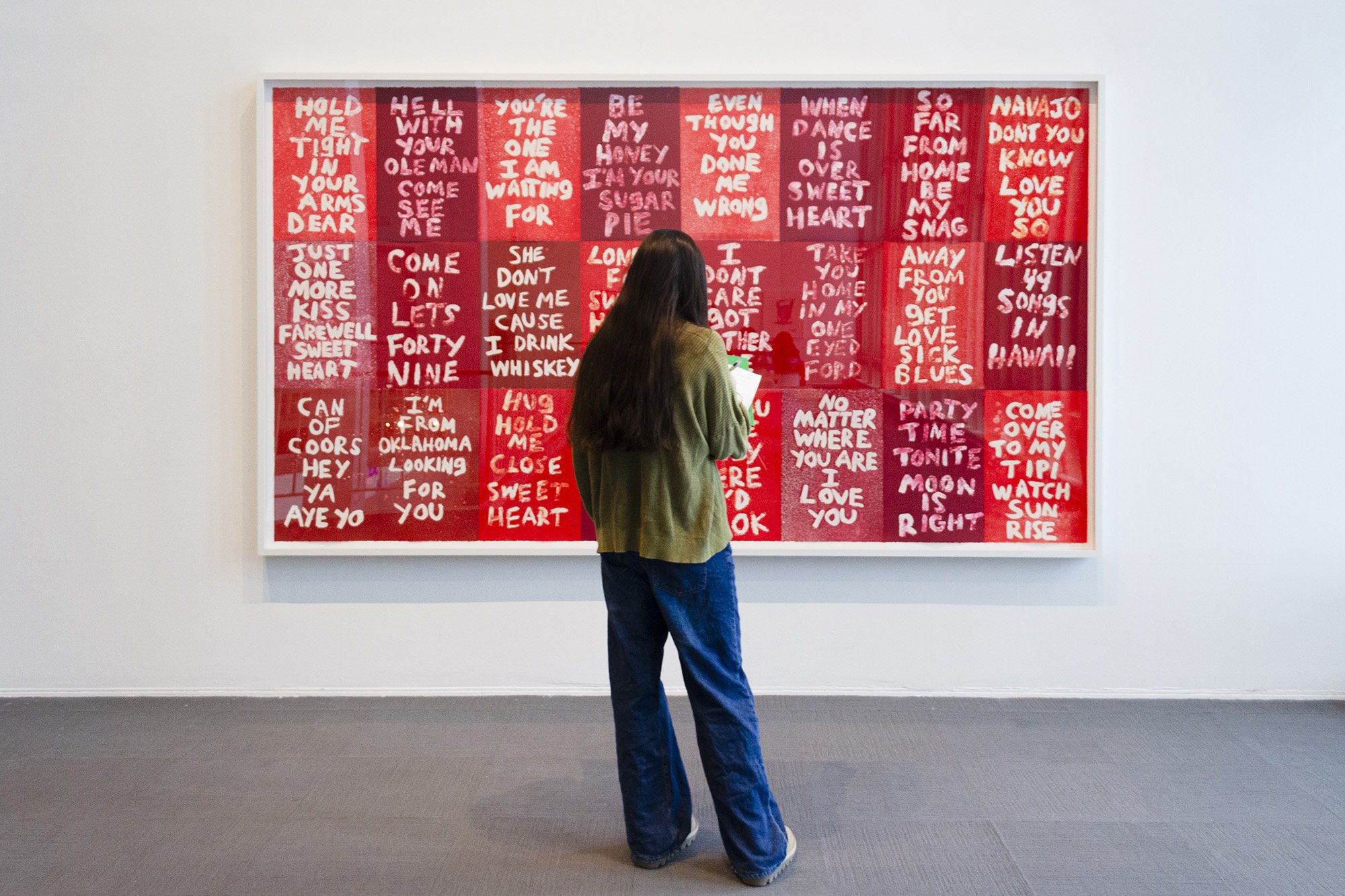Student standing in front of a large framed print