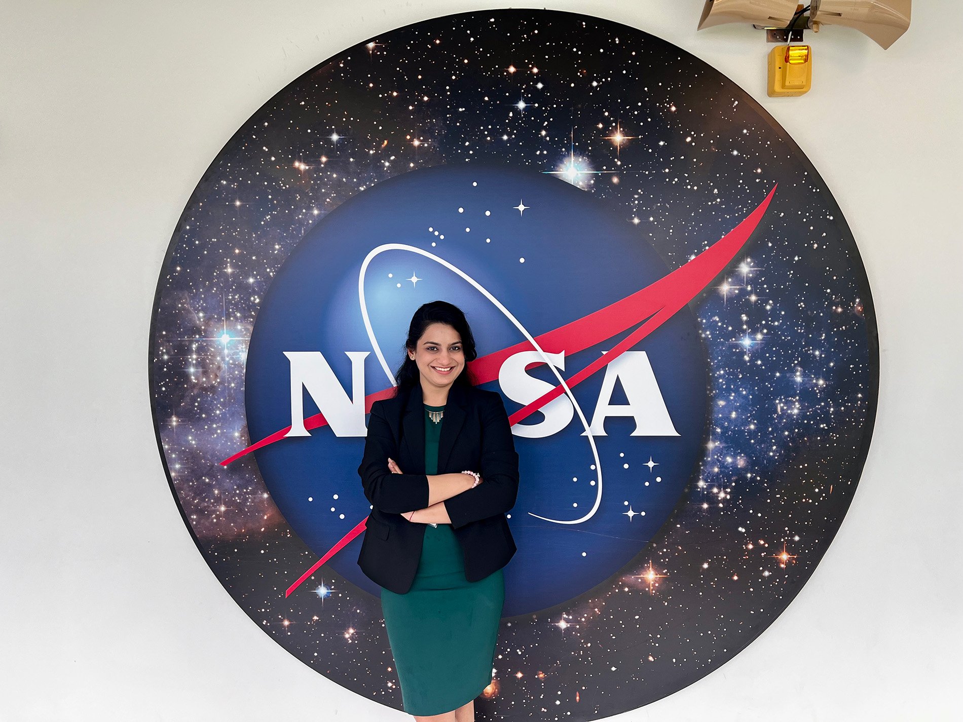 Vasuda Trehan stands in front of a NASA logo.