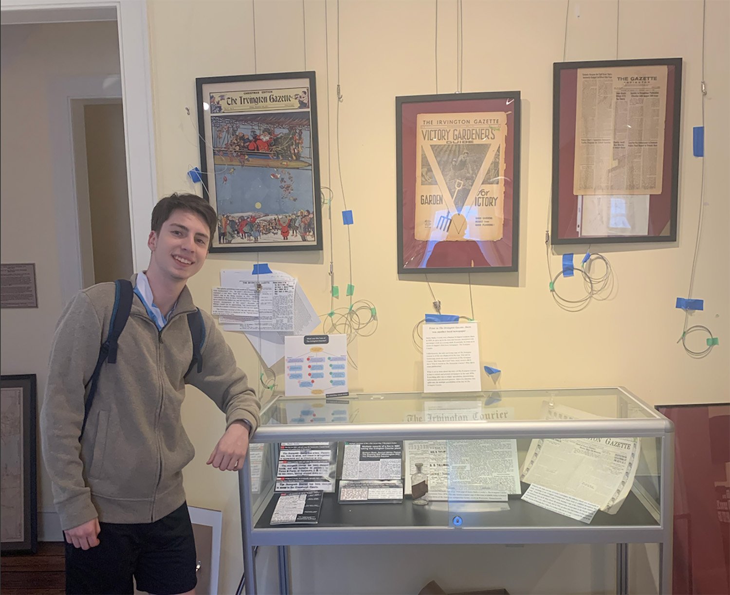 Lavi Ben-Ari stands next to a history exhibit display.
