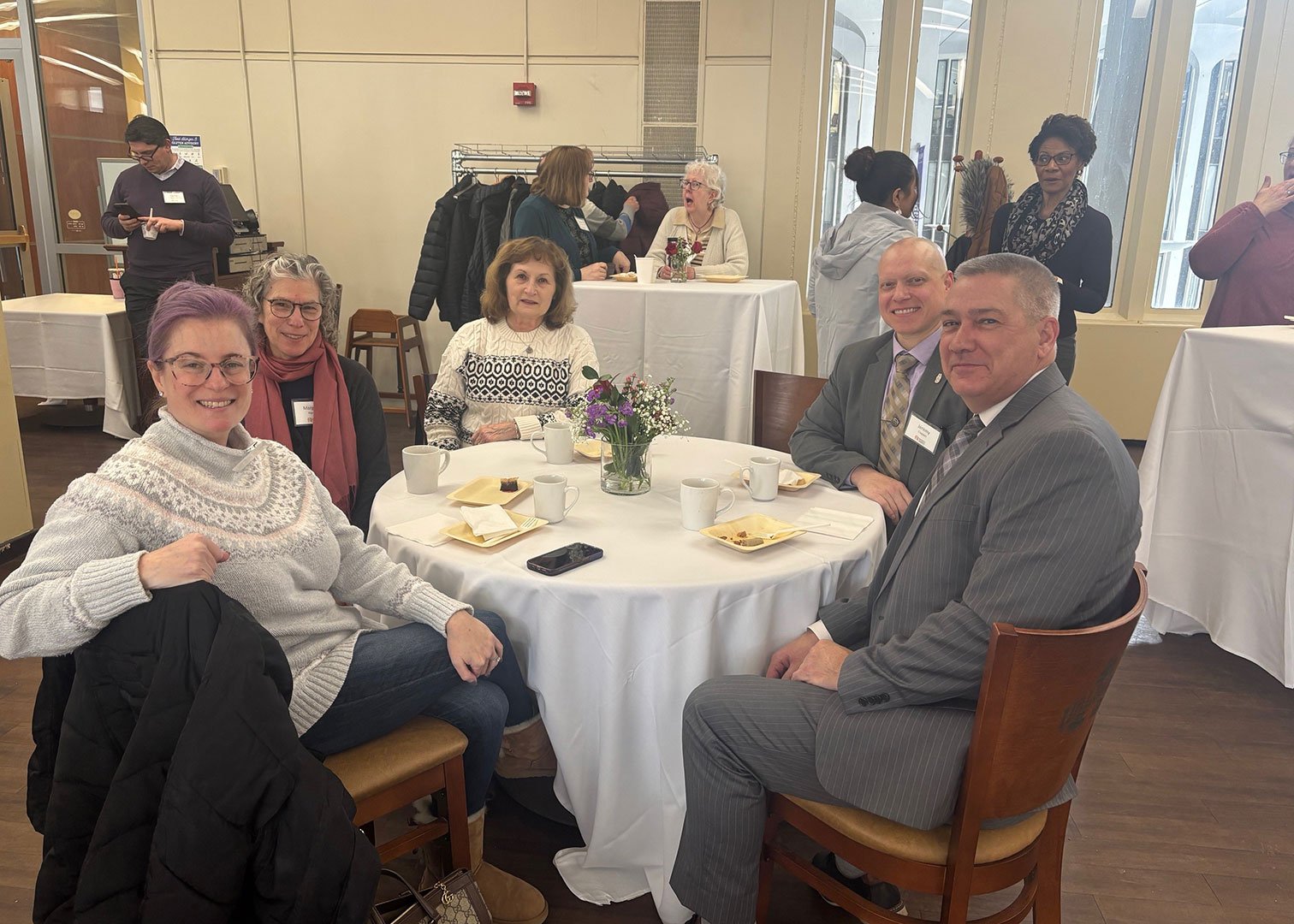 Several faculty and staff donors sit at a table at the reception.