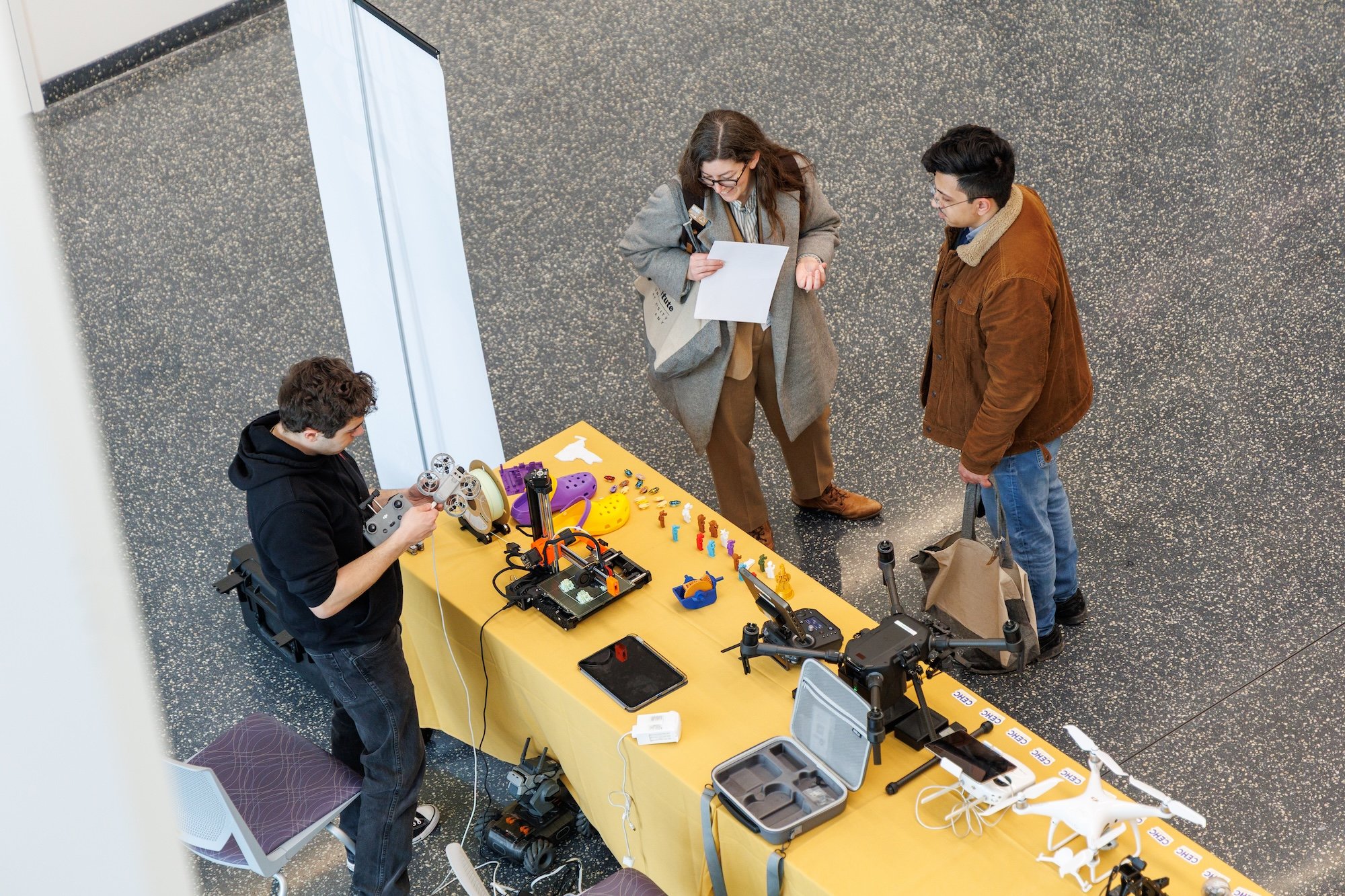 Aerial view of people gathered around a table topped with various technology