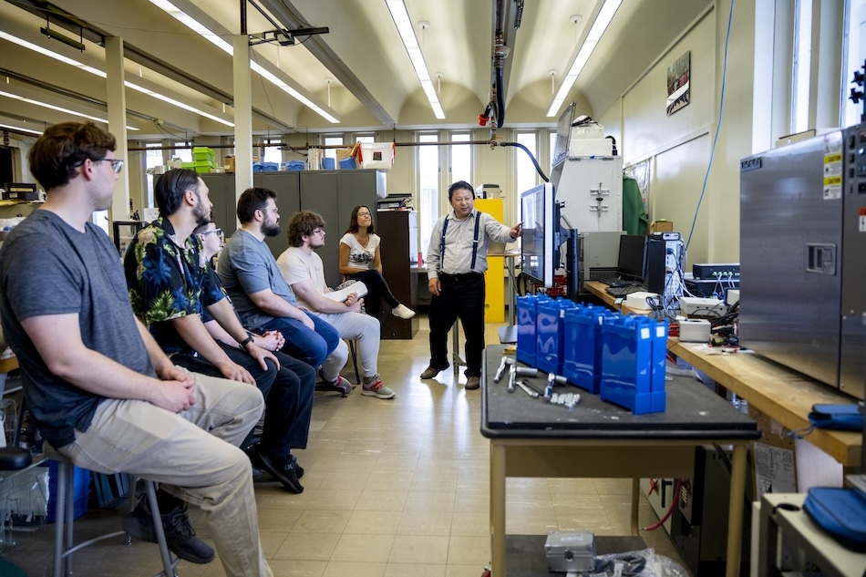 People in safety glasses gather in a laboratory for a training on energy storage technologies