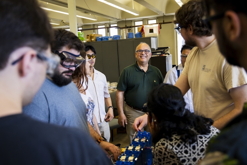 People in safety glasses gather in a laboratory for a training on energy storage technologies