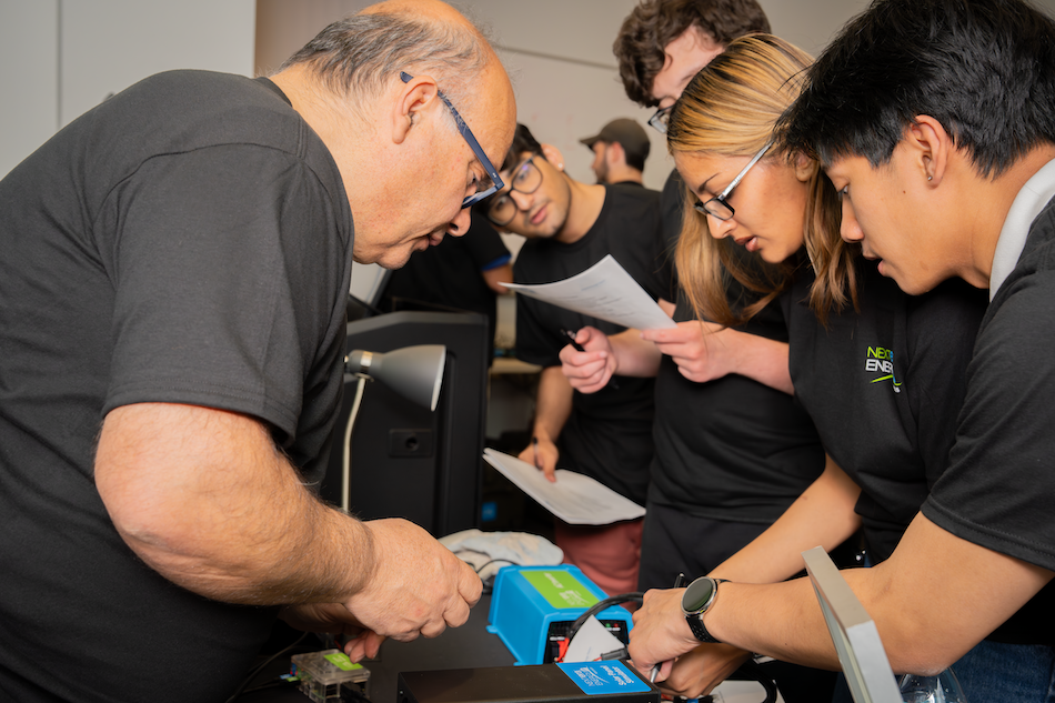 People in safety glasses gather in a laboratory for a training on energy storage technologies