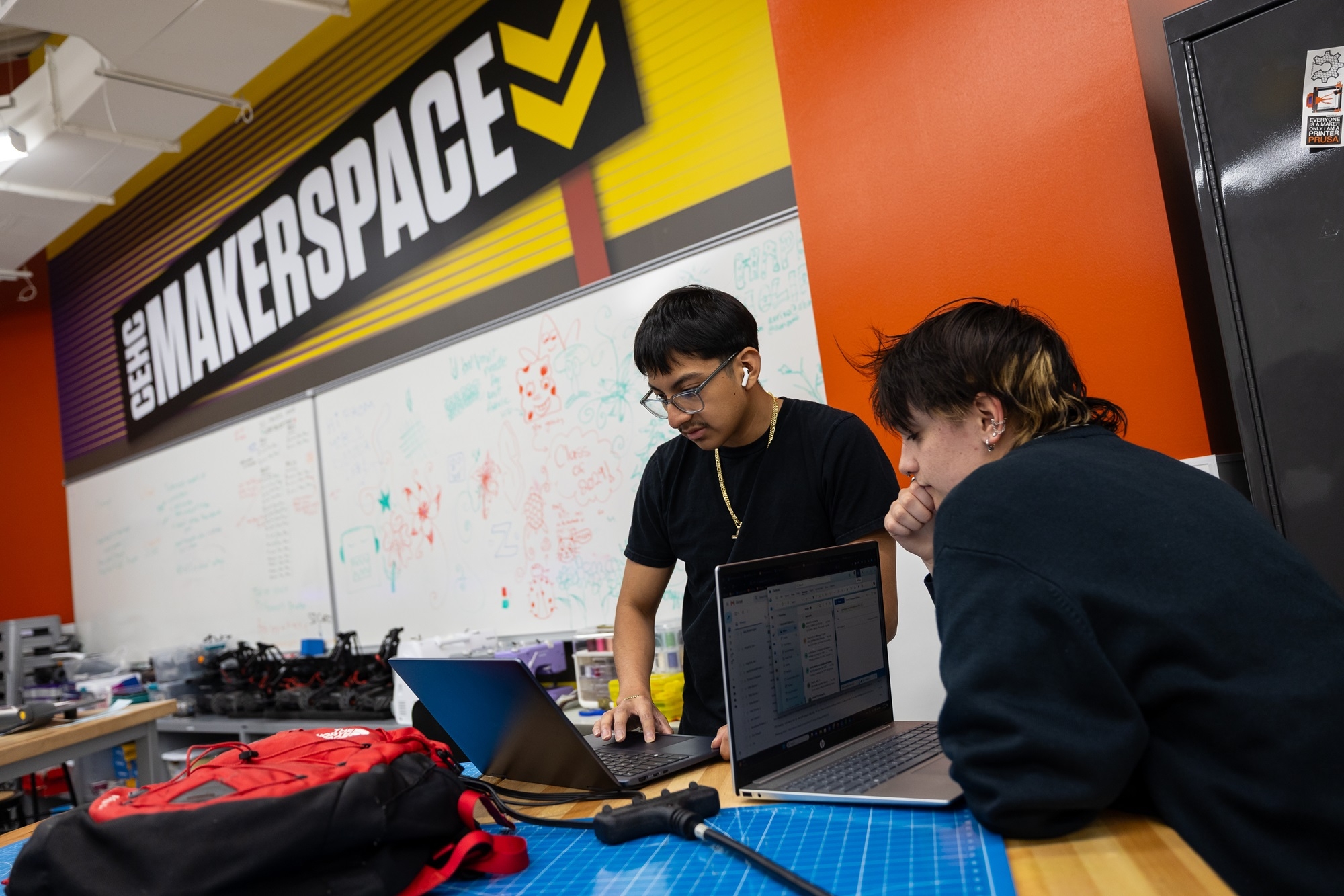 Students view a laptop from inside UAlbany's Makerspace