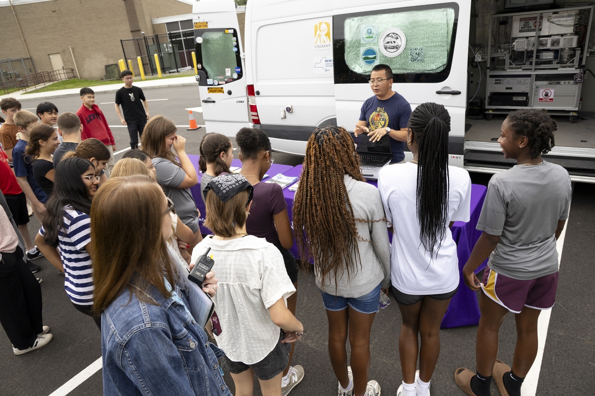 ASRC's Jie Zhang stands with students at Lisha Kill middle school in front of ASRC's mobile lab.