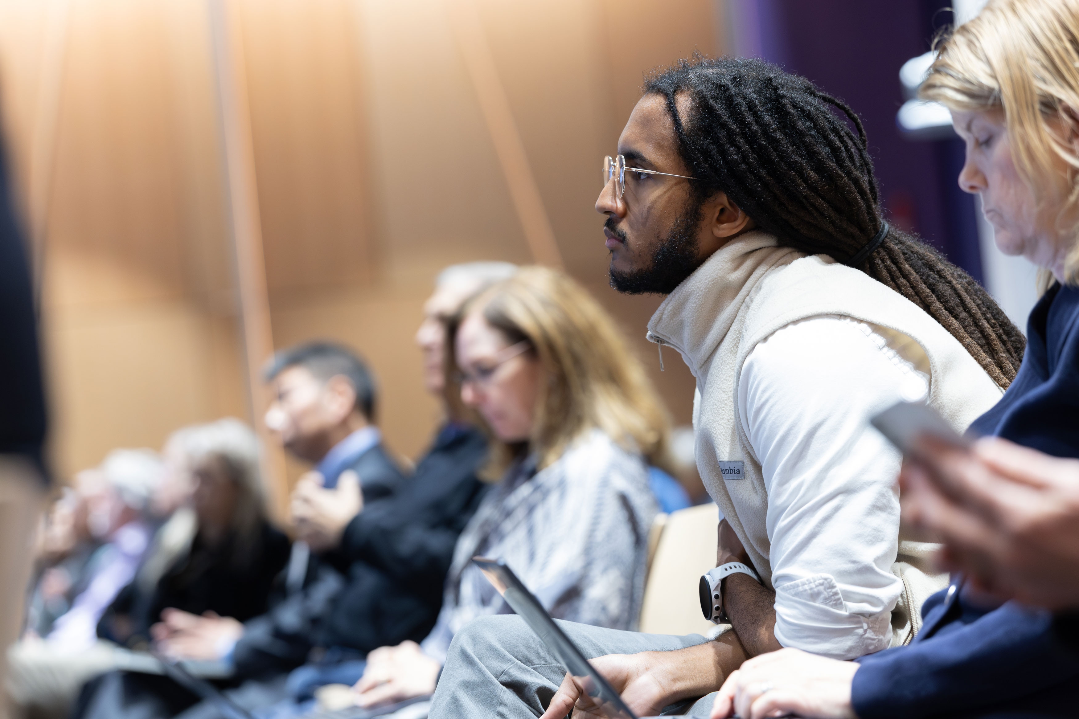 A seated attendee leans forward and listens intently at R&E Week 2025.