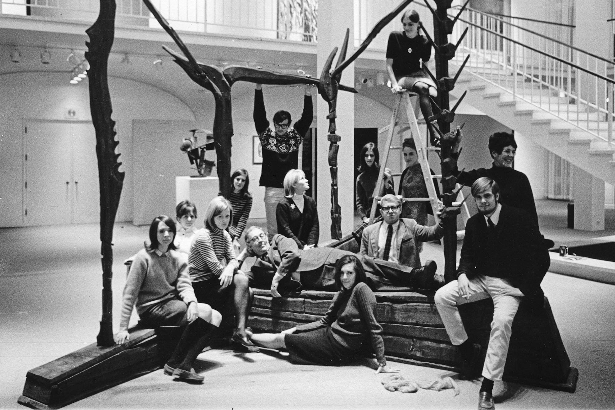 Black and white image of students and artworkers in the museum