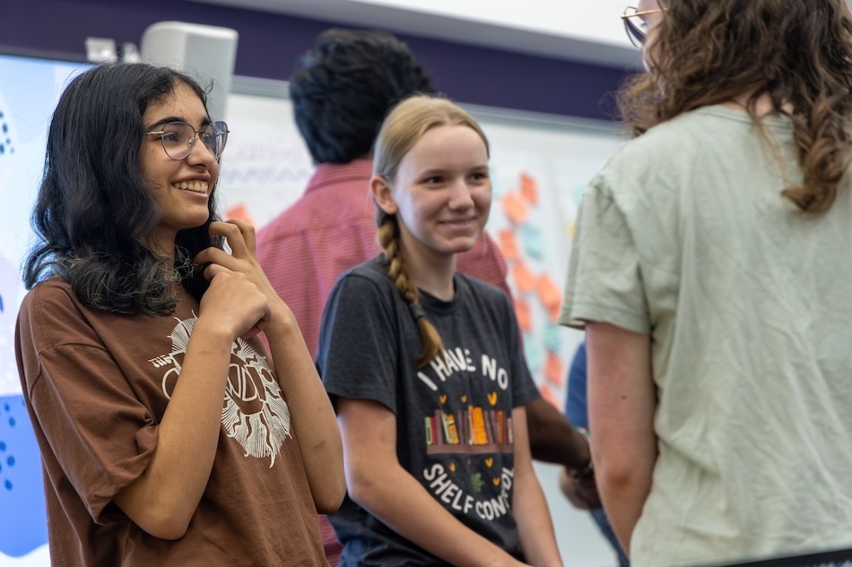 Teens laugh and smile as they participate in a creative writing workshop