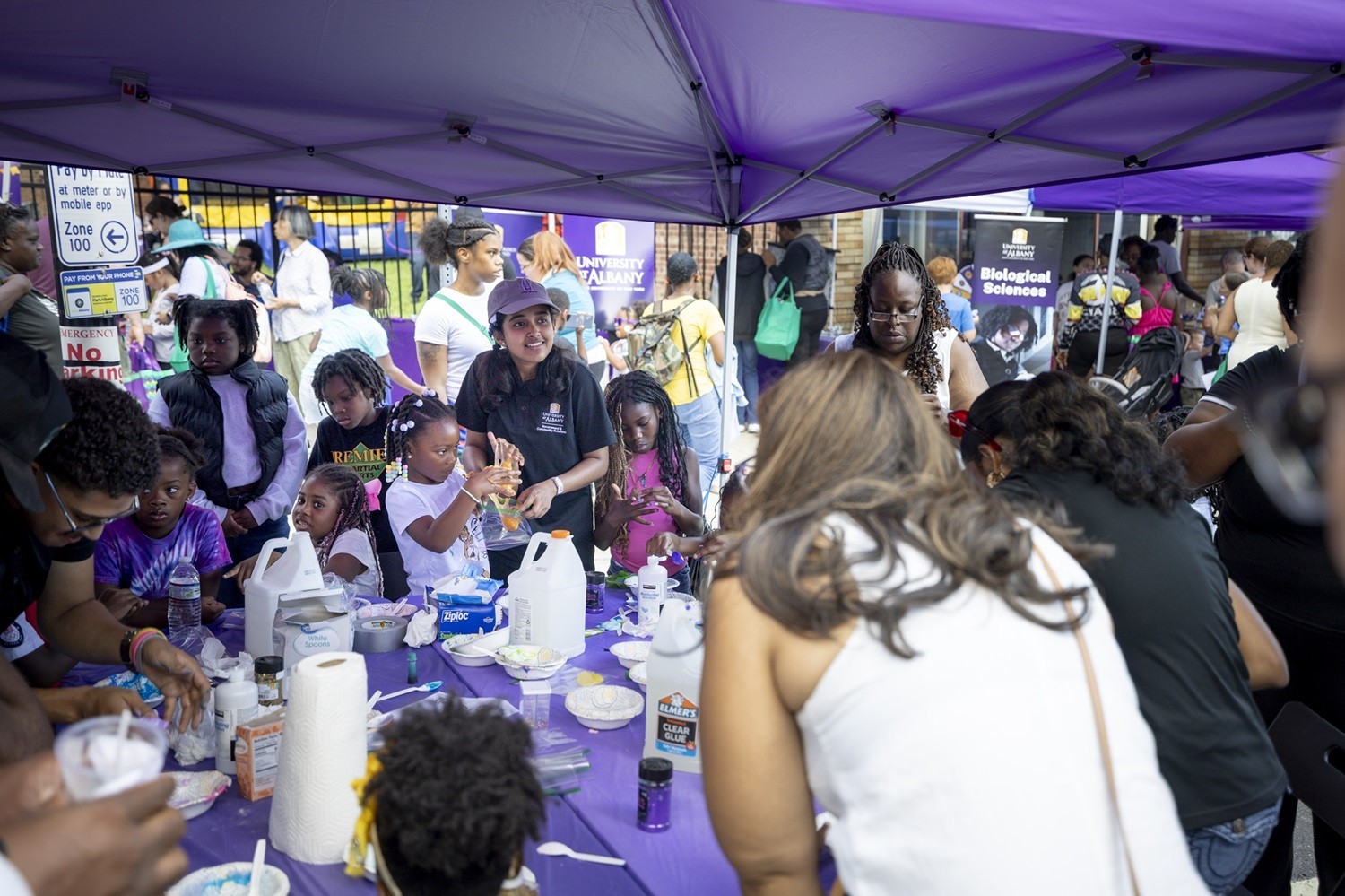 UAlbany students making slime with children.