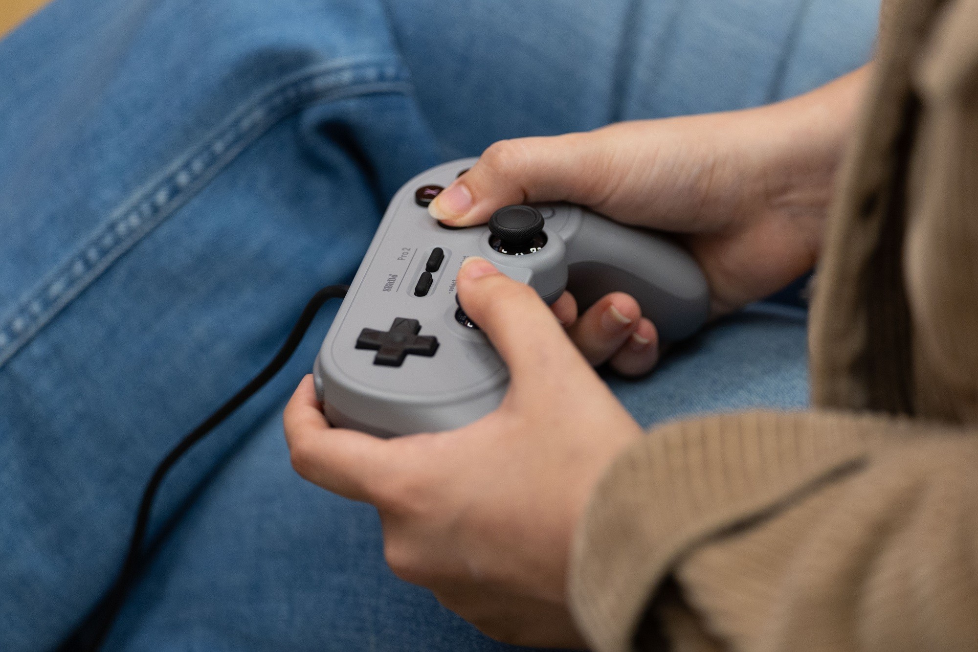 A student holds a retro controller inside the Game Hub.