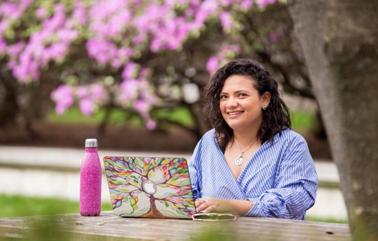 UAlbany student on laptop in garden