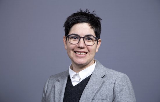 Dr. Feingold smiles at the camera, wearing a grey blazer. A grey background is behind her.