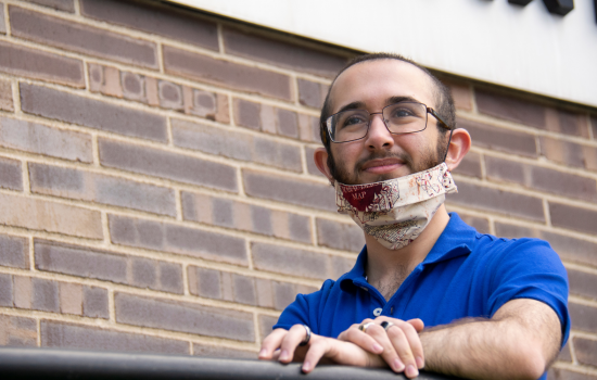 A student stands outside the Albany County Department of Health, wearing a face mask.