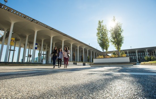 Three students walking on the podium on a sunny day