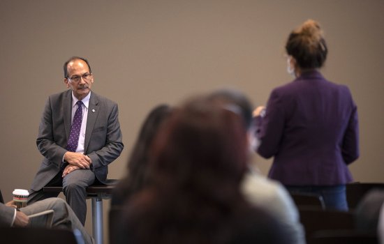 President Rodríguez, seated, listens to a woman ask a question from the audience