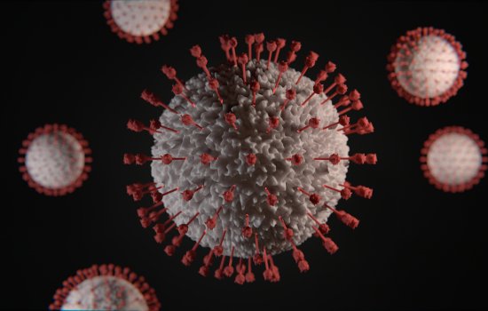 A digital rendering of a covid-19 virus - a grey sphere with red spikes on a black background.
