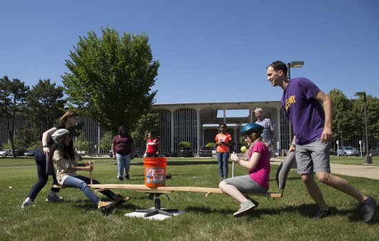 2018 Girls Inc. Eureka program participants being rotated seated on opposite ends of a board with seats.