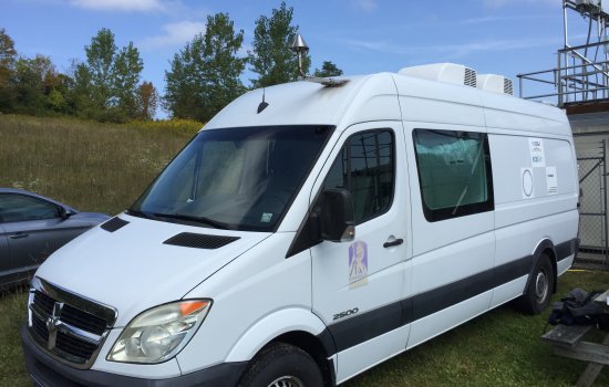 A Dodge 2007 Sprinter van with a UAlbany ASRC logo attached to driver's side front door.