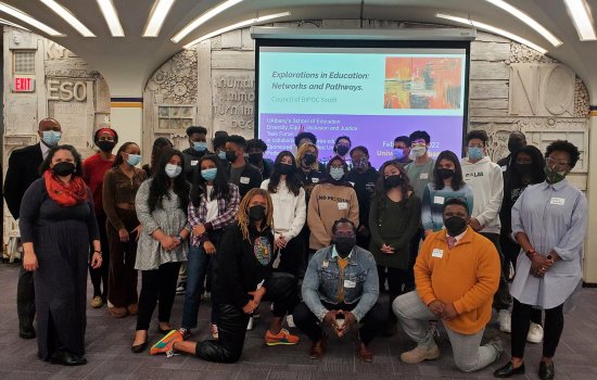 26 students and 2 administrators of color pose in the UAlbany Campus Center