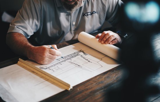 A construction manager looks over blueprint plans