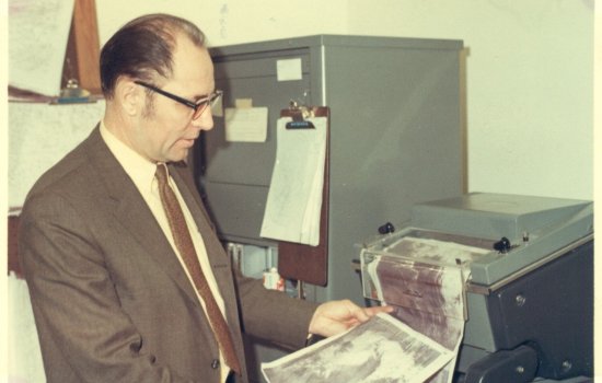 Ray Falconer inspects a weather map on the UAlbany campus.