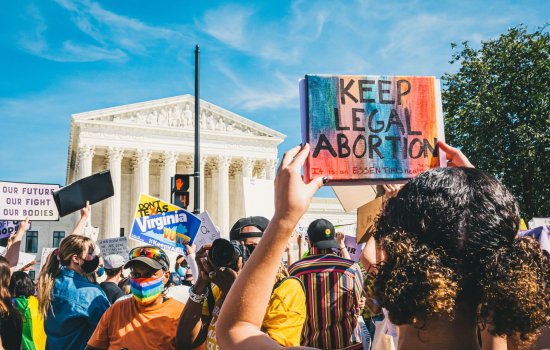 Protesters in front of the Supreme Court hold signs reading "Keep Legal Abortion" and "Our Future Our Fight Our Bodies"