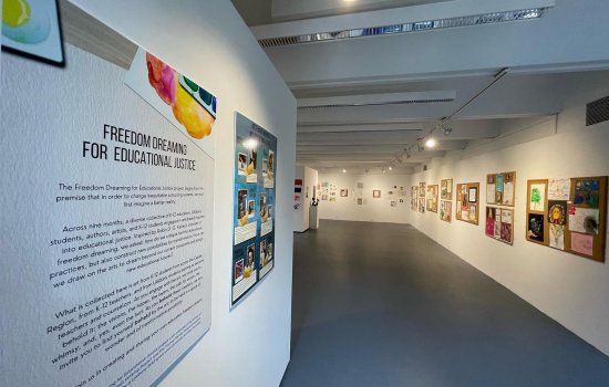 long view of art on display on white walls with overhead lighting at Freedom Dreaming for Educational Justice Exhibition
