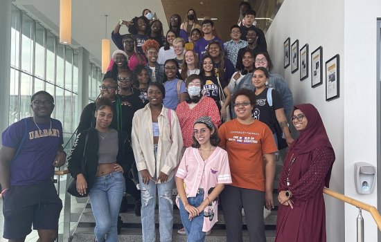 A group of about 40 student educators pose on a staircase.
