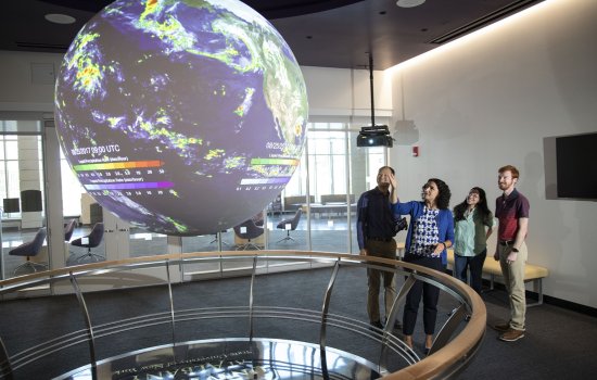 DAES faculty and students observe the "Science on a Sphere" globe inside ETEC.