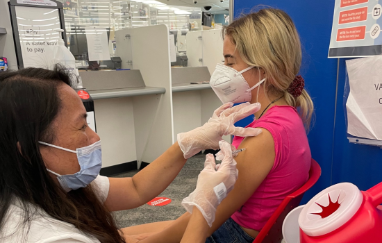 A child sits in a chair to receive a Covid-19 vaccine. 