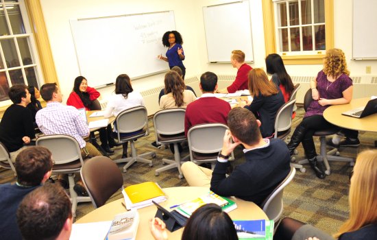 UAlbany Classroom with teacher at front of classroom and students' backs to us.
