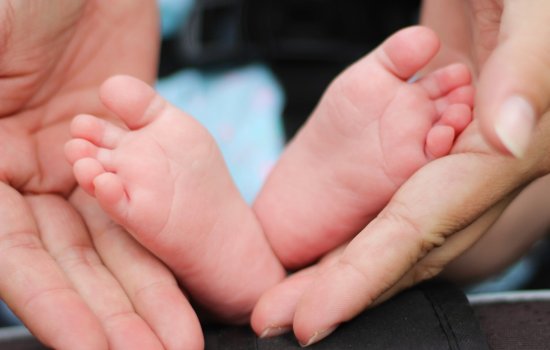 Baby feet held in two hands.