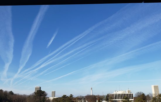 Contrails cover a blue sky above UAlbany's Uptown Campus. 