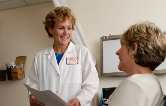 A doctor provides a printed sheet of results to a patient.
