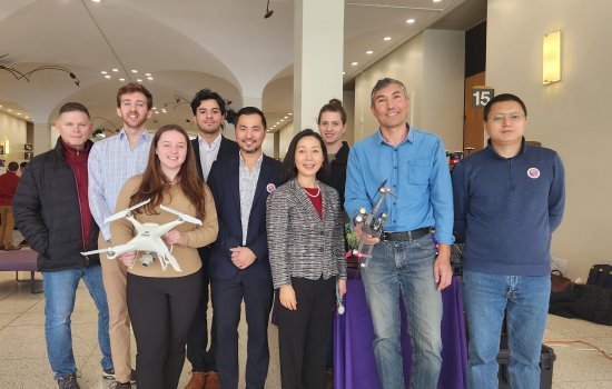 Students and faculty hold up mapping drones in the Lecture Center.