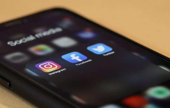 A phone shows three social media icons.