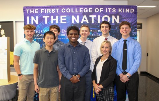 Marcie Fraser stands with EPICH students in front of a CEHC banner.