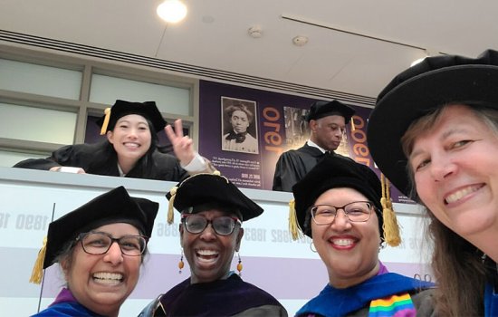 Nora Lum smiles and poses with WGSS faculty at the UAlbany commencement ceremony.