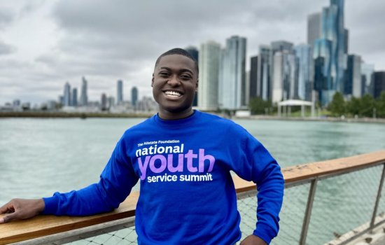  Jaden Gabb stands in front of the Chicago skyline in a National Youth Service Summit sweatshirt.
