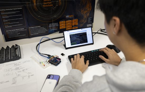 A student reviews code on a tablet from the Cyber Resilient Interdependent Systems & Infrastructure Solutions Lab at ETEC. (photo by Patrick Dodson)