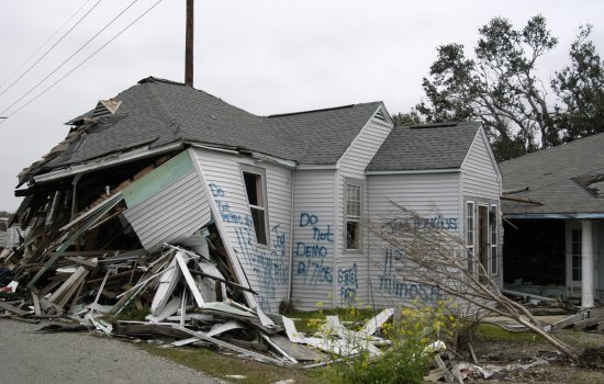 A damaged home with "do not demo" signage on it following Hurricane Katrina.