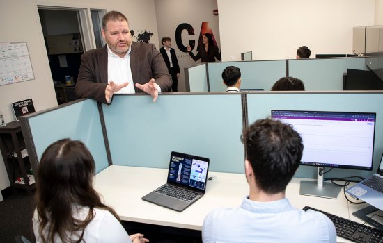 Brandon Behlendorf talks with students inside the Center for Advanced Red Teaming at ETEC.