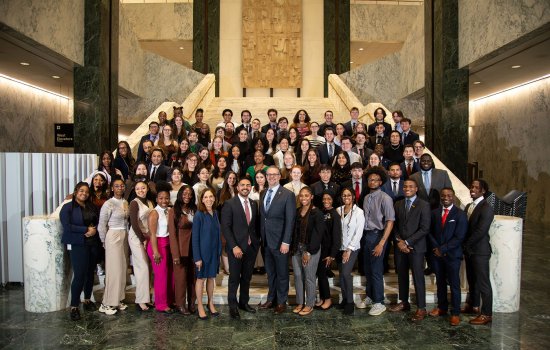 UAlbany student interns join for a class photo on a set of stairs inside the Legislative Office Building.