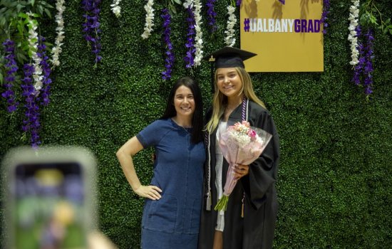 Erin Couture stands with a student at UAlbany's 2024 commencement festivities.
