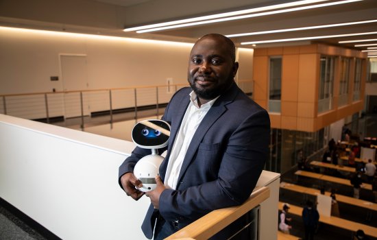 CEHC Benjamin Yankson holds a robot at the new ETEC building.