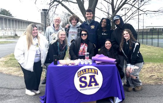 Student Association students huddle around a table.
