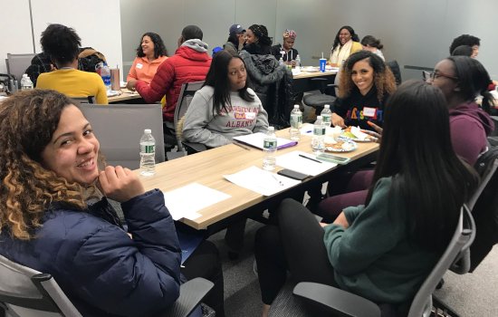 students sitting around tables smiling and talking